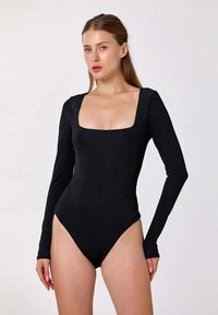 Bodysuit noir à manches longues avec un décolleté carré et une coupe ajustée. Le tissu a une texture lisse, offrant une silhouette élégante.