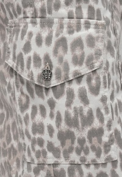 Γκρι ύφασμα με σχέδιο λεοπάρδαλης. Διαθέτει τσέπη με καπάκι και στρογγυλό μεταλλικό κουμπί με ανάγλυφο κείμενο. Η υφή φαίνεται ομαλή.