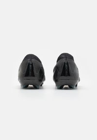 Pair of black Nike Mercurial soccer cleats shown from the rear, highlighting the heels and studded outsoles on a white background.