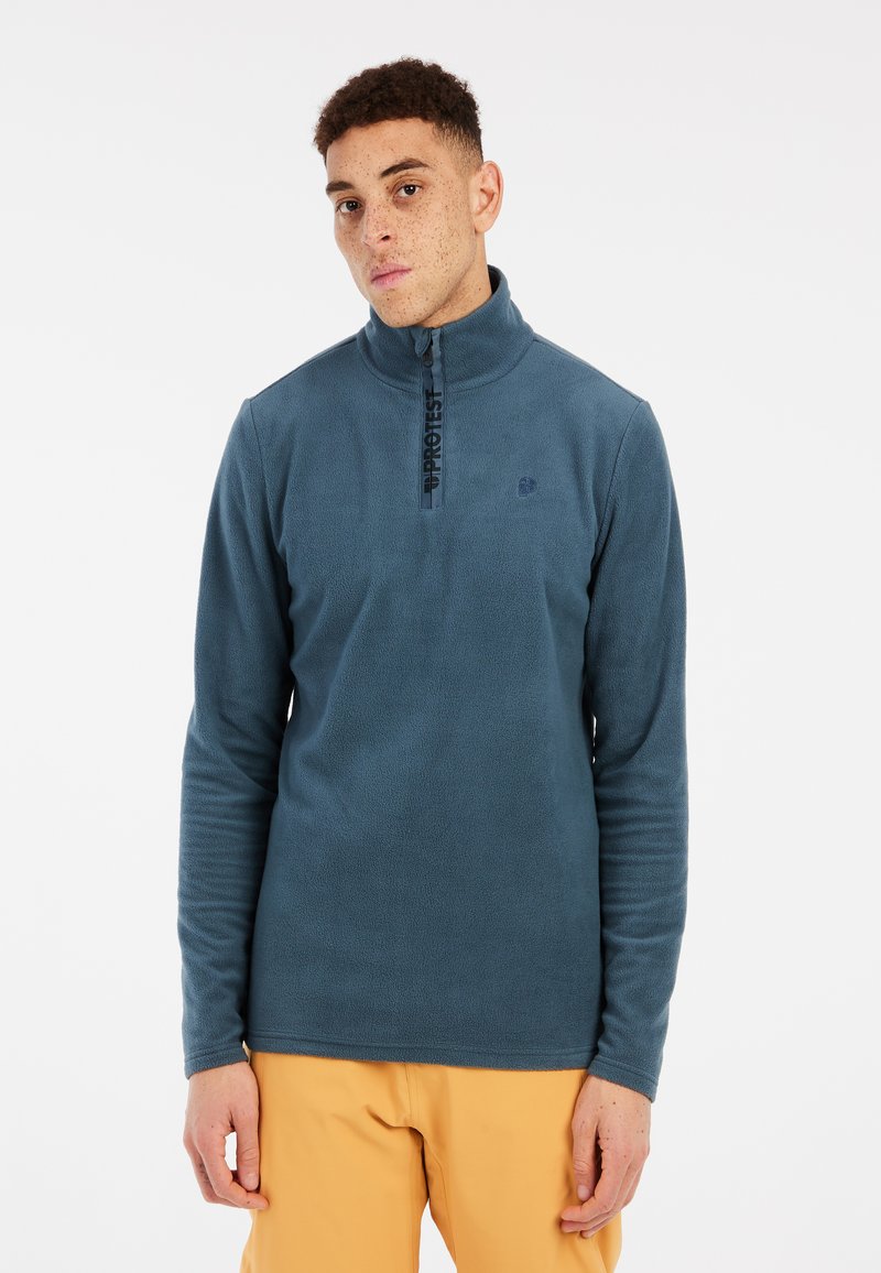 Pullover in pile blu scuro con colletto a mezza zip, caratterizzato da una texture a coste e una stampa del logo lungo la zip. Maniche lunghe.