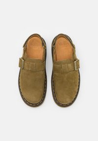 Pantofi slip-on din suede verde, cu o curea și prindere cu cataramă, având o talpă maro și cusături galbene. Textură netedă, cu branț căptușit.