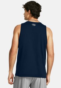 Tengerészkék, ujjatlan sport tank top, puha pamut keverékből készült, lekerekített nyakkivágással és logóval a hátsó részen. Mosógépben mosható.