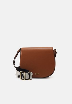 Brown leather crossbody bag with black and white adjustable strap and gold DKNY logo on front.