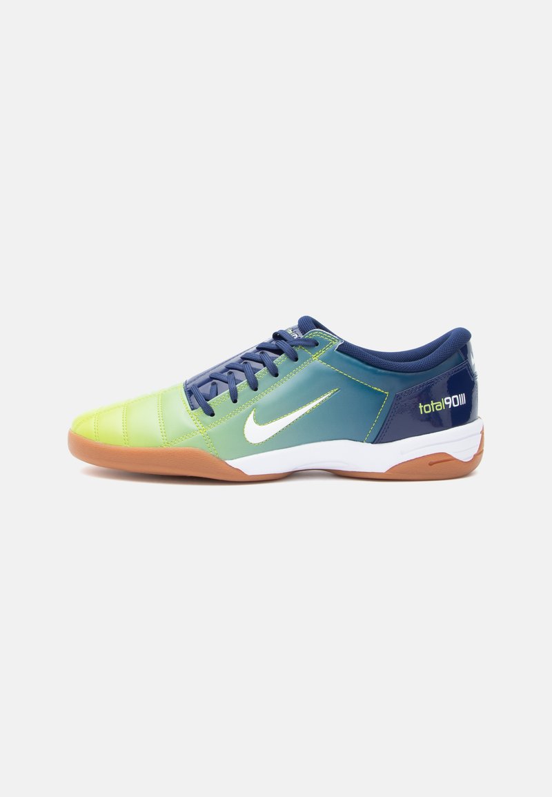 Low-profile athletic shoe with lime green to dark blue gradient, white Nike swoosh, gum sole, and "total 90 III" branding on heel.