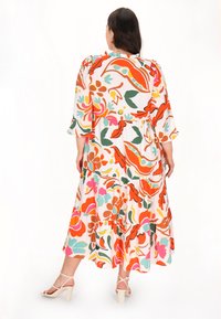 Florales Midikleid mit gestuftem Design, das lebendige Muster in Orange, Pink, Grün und Blau zeigt. Leichter Stoff mit ausgestellten Ärmeln.