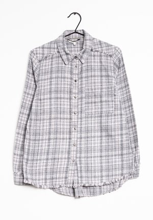 Camicia a quadri grigia e bianca con colletto, maniche lunghe, taschino sul petto e dettagli con orlo sfrangiato. Realizzata in un tessuto morbido e testurizzato.
