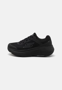 Zapatilla deportiva negra con parte superior de malla, suela acolchada y cuello con padding. Presenta un logo en el costado y detalles texturizados en la suela.