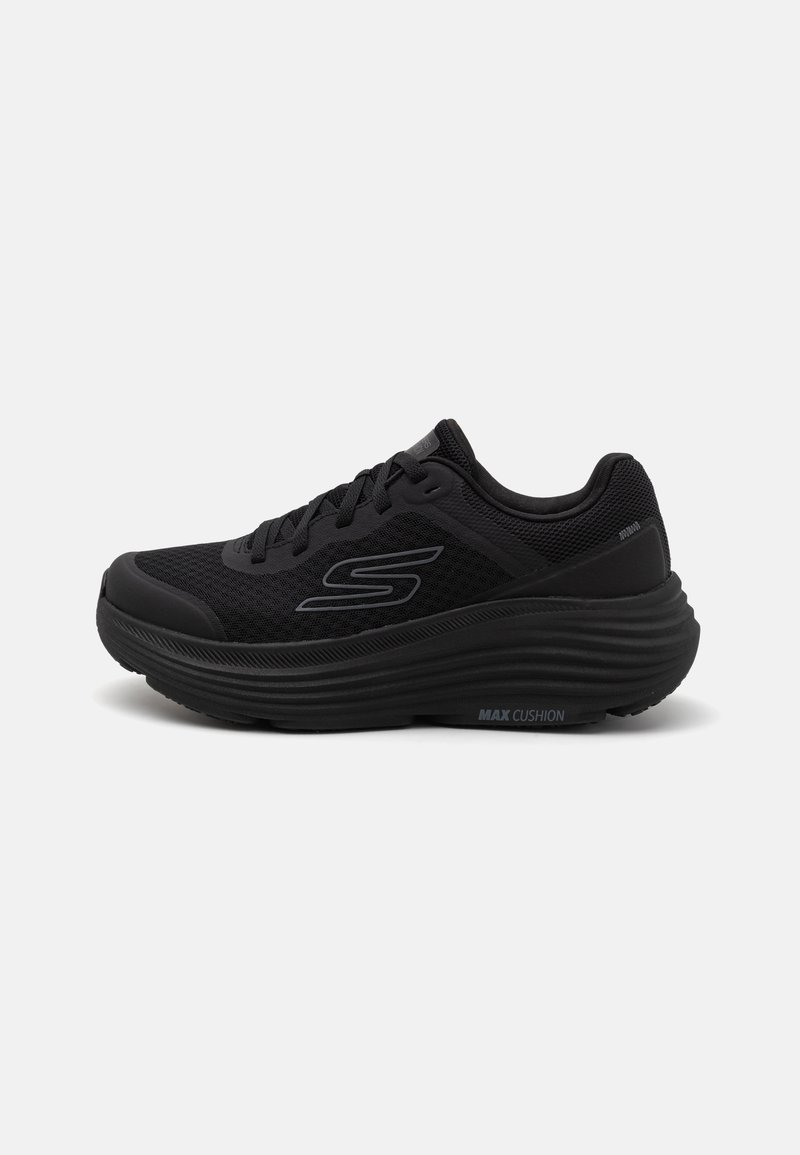 Zapatilla deportiva negra con parte superior de malla, suela acolchada y cuello con padding. Presenta un logo en el costado y detalles texturizados en la suela.