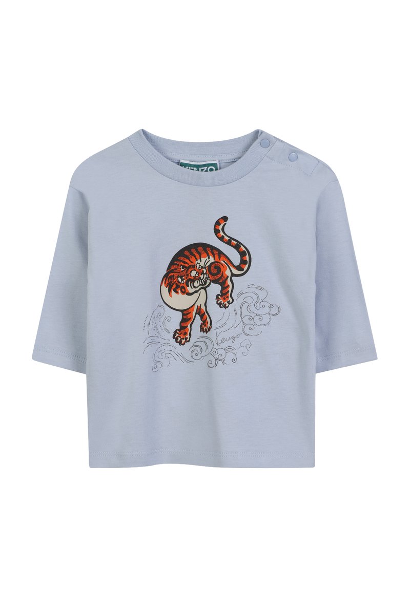 T-shirt bleu clair à manches courtes avec un col rond, présentant un tigre brodé en orange et noir, ainsi que des motifs de vagues en argent.