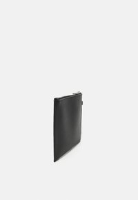 Bolsa de couro preto com textura suave, formato retangular e fecho prateado. Design minimalista sem padrões ou acentos visíveis.