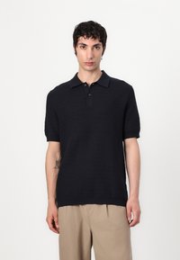Korte erm, mørkeblå polo-skjorte med et teksturert, zigzag-mønster, tre knappelukkinger og klassisk krage.