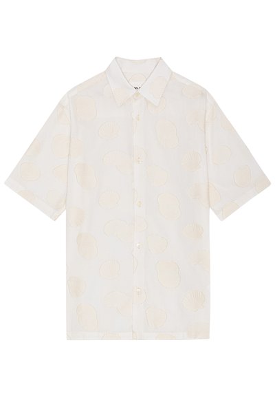 Korte mouw shirt van witte stof met een gestructureerd schelpenpatroon. Beschikt over een kraag en vijf knopen aan de voorkant. Lichte ontwerp.