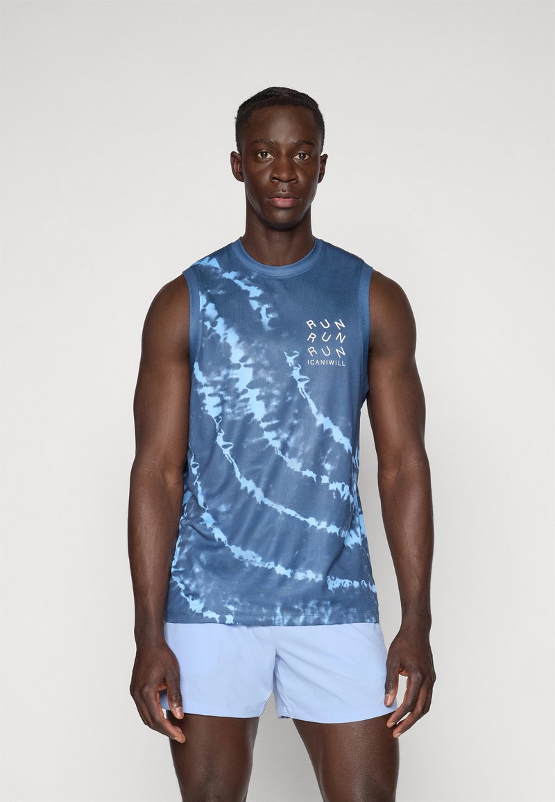 Chemise sans manches en tie-dye bleu avec un col rond, ornée de texte blanc et en tissu léger, associée à un short bleu clair.
