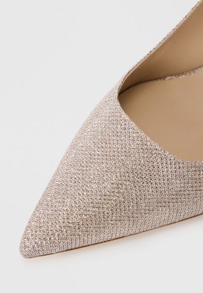 Pointed-toe shoe in light pink with a textured, shimmering surface and a smooth interior, featuring an elegant cut at the front opening.