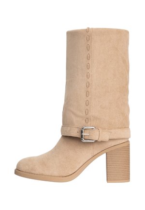 Beige ruskind støvle til midt på læggen med blokhæl, dekorative syninger og en spænde-rem rundt om anklen.