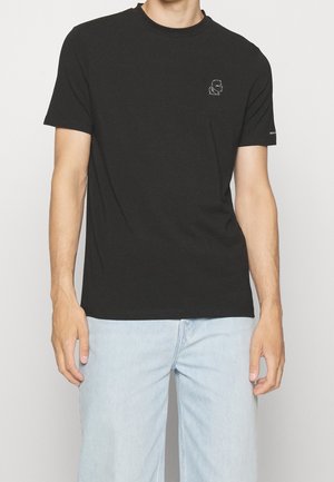 Schwarzes Baumwoll-T-Shirt mit rundem Halsausschnitt und kurzen Ärmeln, das ein dezentes besticktes Grafikdesign auf der linken Brust zeigt.