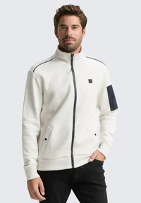 Lichtgrijs ritsjack met een diamond-patroon textuur, marineblauwe accenten, twee zijzakken en een staande kraag.