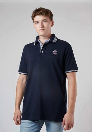 Polo marine à manches courtes, avec un col à carreaux contrastés, un logo brodé et des accents rayés sur les manches.