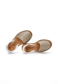 Zapatos deslizables tejidos marrones con una parte superior de tela beige, suela de cuero marrón claro y acentos blancos. Marcados como "ETIKA MADE IN SPAIN" en la plantilla. Talla 36.