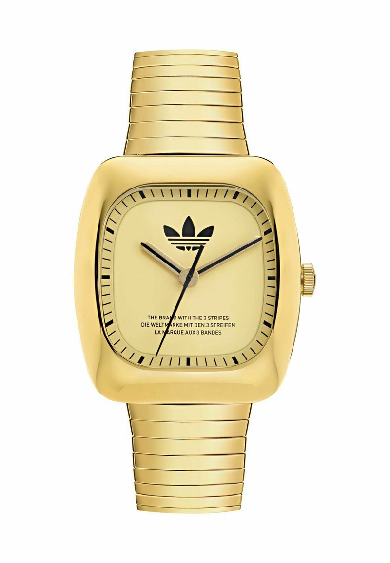Montre rectangulaire dorée avec un bracelet en métal rainuré, cadran minimaliste avec des index horaires noirs et un logo, et deux aiguilles fines.