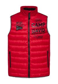 Rote, gepolsterte Weste mit hohem Kragen, versehen mit schwarzem Drucktext und Logos. Zwei seitliche Reißverschlusstaschen und kontrastierende Streifen entlang der Nähte.