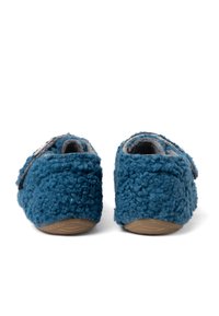 Pantofole in lana blu con un'esterno testurizzato e peloso e un interno grigio, dotate di suola piatta e cinturino regolabile per una vestibilità sicura.
