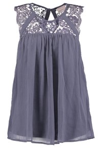 Vestido sin mangas en lavanda con canesú de encaje y falda plisada. Cuenta con cierre en la espalda con ojal y tela ligera y texturizada.
