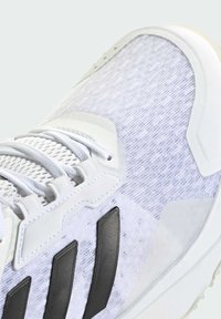 Białe buty sportowe z teksturowaną siateczką na cholewce, czarnymi akcentami i białymi sznurówkami. Posiadają trwałą gumową podeszwę oraz elegancki design.