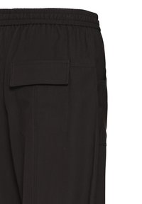 Pantalon noir en tissu texturé, doté d'une ceinture élastique et de poches latérales avec rabats.