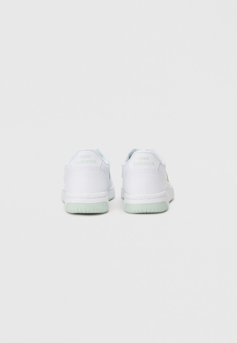 Zapatillas blancas con una superficie texturizada, con acentos en verde claro en el lateral y la suela, que presentan un pequeño logo en el talón y un cuello acolchado.
