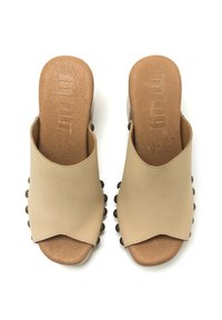 Mule in pelle beige con punta aperta e bordo ondulato, decorate con borchie metalliche tonde lungo il lato. Soletta testurizzata per il massimo comfort.