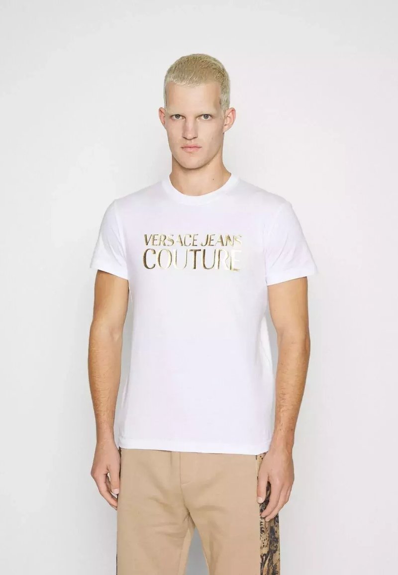 T-shirt bianco in cotone con stampa in foglia d'oro di "VERSACE JEANS COUTURE" sul davanti. Maniche corte, scollatura rotonda, vestibilità casual.