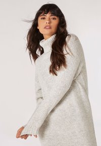 Lichtgrijze, geribde turtleneck trui gemaakt van zachte, textuurstof, met lange mouwen en aansluitende manchetten en een ontspannen pasvorm.