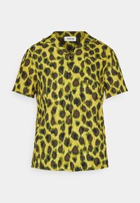 Camicia a maniche corte in tessuto leggero, presenta una base gialla con macchie leopardate verdi e marroni, chiusura a bottoni e taschino sul petto.
