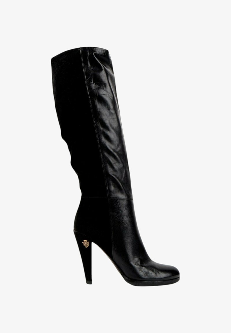 Botte noire en cuir montant jusqu'au genou avec un talon haut effilé et un petit emblème doré sur le côté du talon, vue de profil droit.