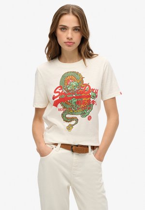 T-shirt en coton couleur crème avec un grand graphique de dragon coloré et le texte "Superdry" en rouge. Coupe décontractée avec des manches courtes.