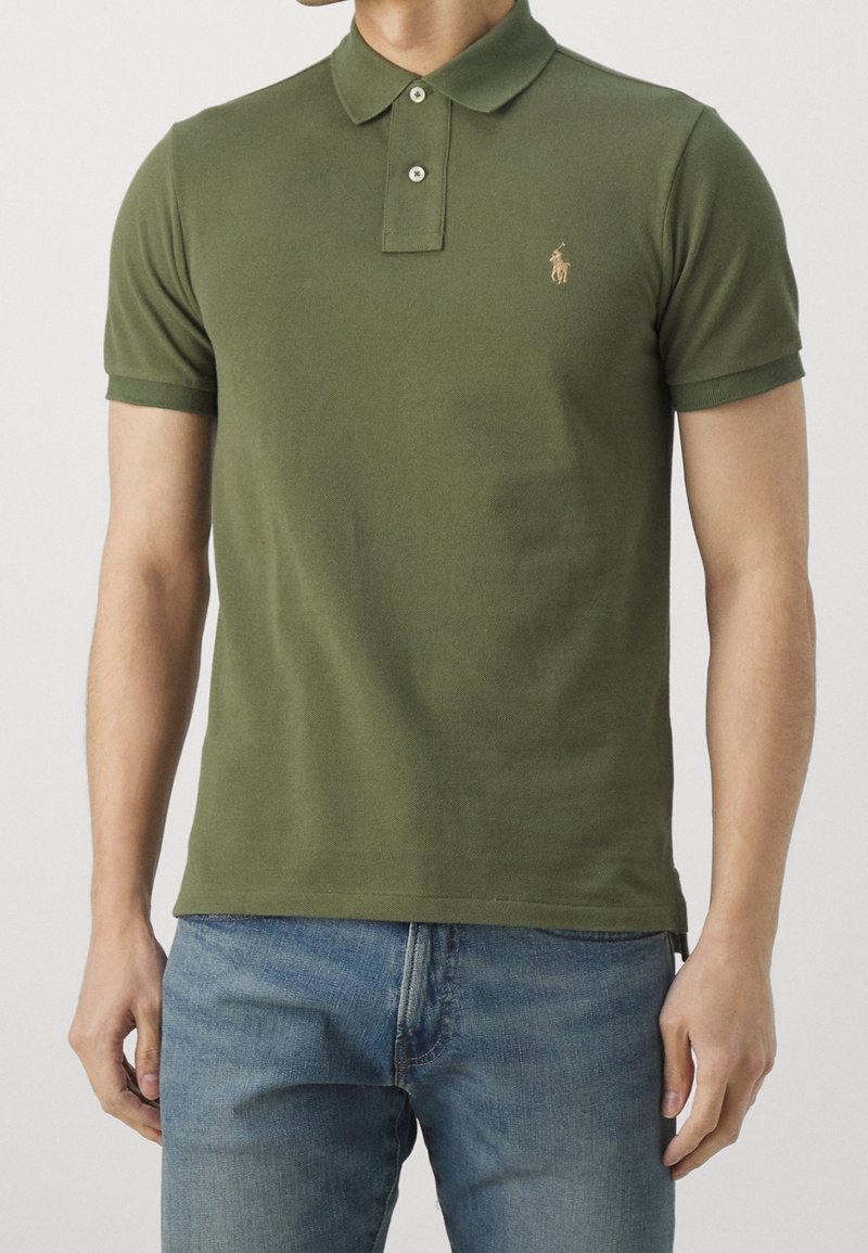 Polo shirt verde a maniche corte realizzato in cotone liscio. Presenta un colletto a punta e un piccolo logo ricamato sul petto. Design aderente.