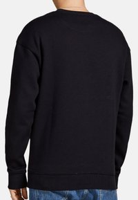 Svart sweatshirt i bomull med långa ärmar, rund halsringning, ribbade ärmslut och fåll. Slät textur, minimalistisk design.