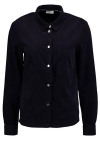 Camicia a maniche lunghe in velluto a coste di un blu navy scuro, con colletto, bottoni a scatto frontali e una tasca singola sul petto.