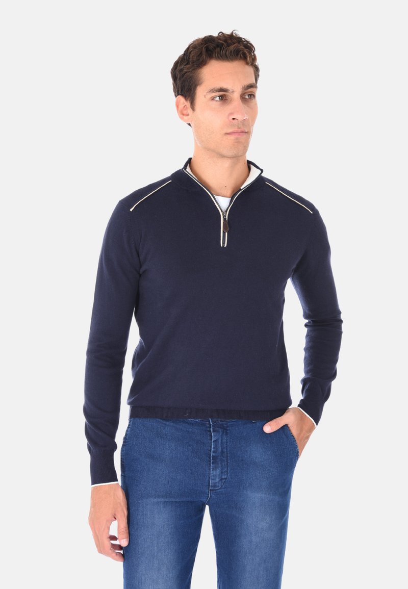 Maglione navy a maglia con colletto a mezza zip, caratterizzato da cuciture bianche a contrasto sulle spalle, design aderente e polsini e orlo a coste.