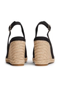 Μαύρα σανδάλια πλατφόρμας espadrille με τακούνι τυλιγμένο σε τζούτα, με στρογγυλεμένη πίσω όψη, ρυθμιζόμενο λουράκι αστραγάλου και πάνω μέρος από λείο ύφασμα.