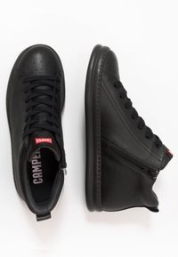 Sorte lær høye sneakers med strukturert finish, snøring foran, glidelås på siden og rødt "Camper"-logo på tungen.