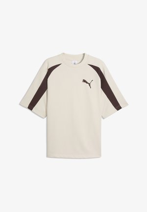 Beige sportsskjorte med korte ærmer, mørkebrune striber på siden og Puma-logo på venstre bryst.