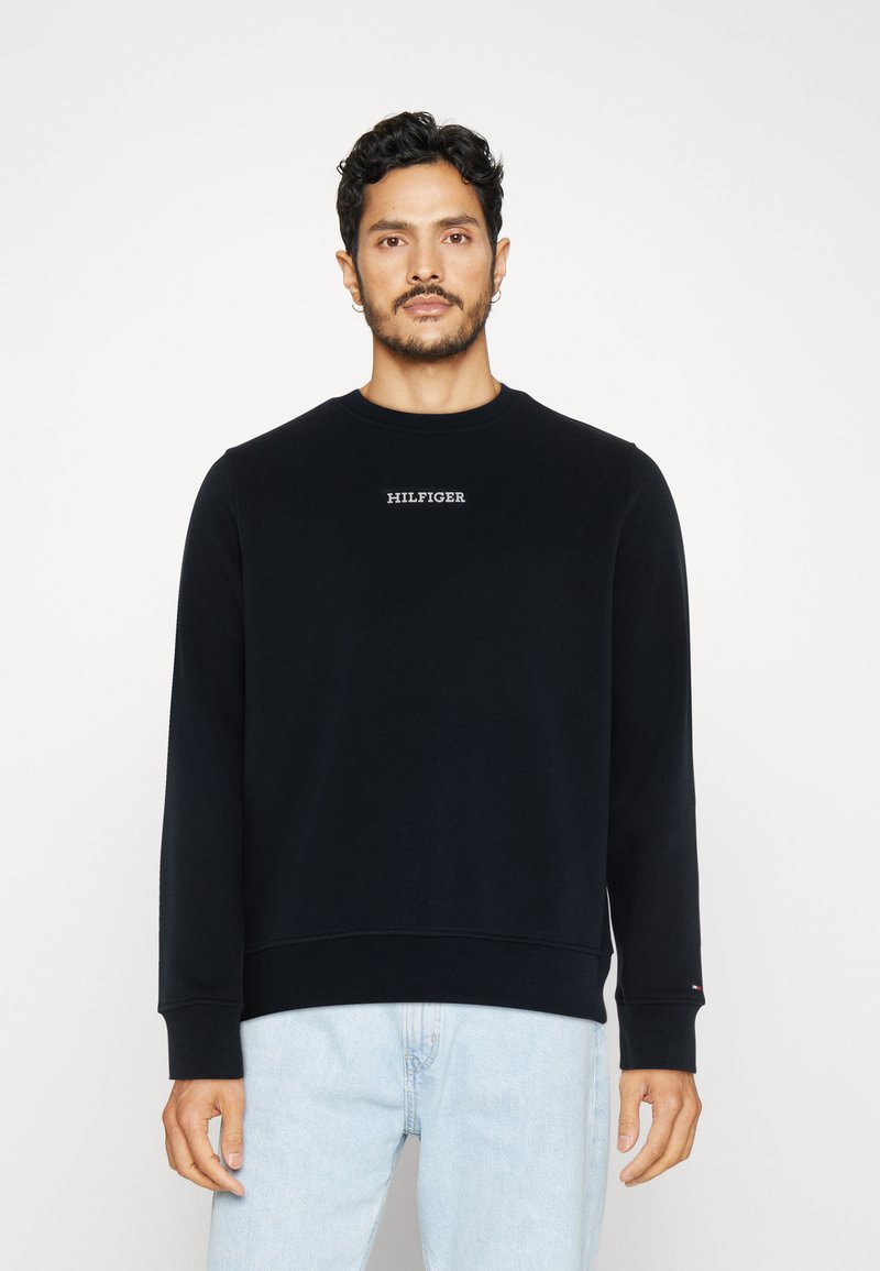 Felpa nera con colletto a girocollo realizzata in cotone, caratterizzata da un piccolo logo ricamato sul petto, polsini a coste e una vestibilità rilassata.