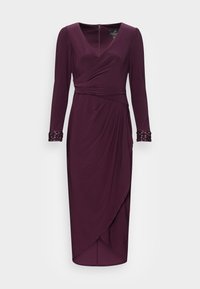 Viininpunainen mekko, jossa on pitkät hihat, V-aukko, kietaisumalli, kerätty vyötärö ja koristellut kalvosimet. Pehmeä, laskeutuva kangas, jossa liehuva yksityiskohta.