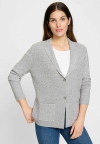 Hellgraue Strickjacke aus geripptem Strickstoff. Verfügt über einen Reverskragen, einen einzelnen Knopfverschluss und zwei Fronttaschen.