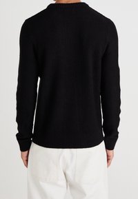 Czarny sweter dziany o fakturowanej powierzchni, z długimi rękawami i okrągłym dekoltem, z prążkowanymi mankietami i dolnym brzegiem.