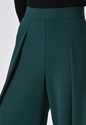 Weite, türkisfarbene Hosen mit gefälteltem Detail an der Taille. Hergestellt aus einem glatten Stoff mit matter Oberfläche.