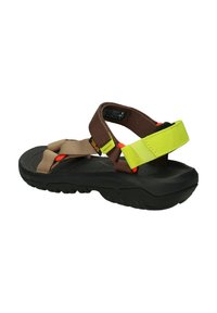 Sandalias marrones y beige con suela negra, que cuentan con correas ajustables en acentos amarillos y naranjas para un ajuste seguro y comodidad.