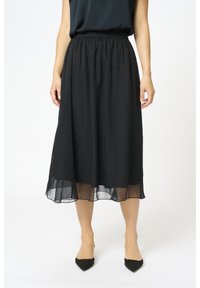 Gonna midi nera realizzata in tessuto leggero con sovrapposizione trasparente. Presenta una vita elasticizzata e una silhouette fluida.